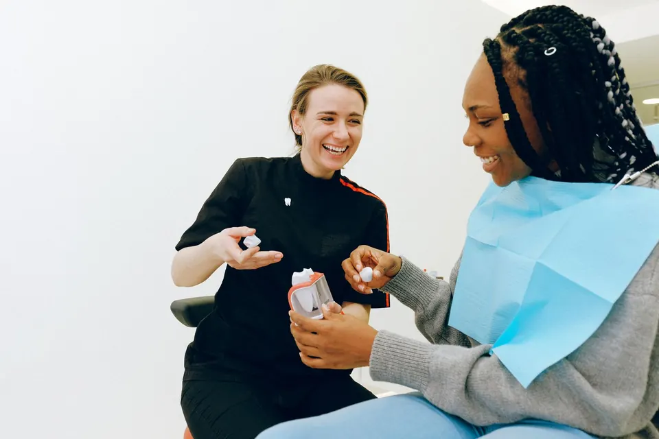 Dentist showing a patient a dental model while explaining treatment
