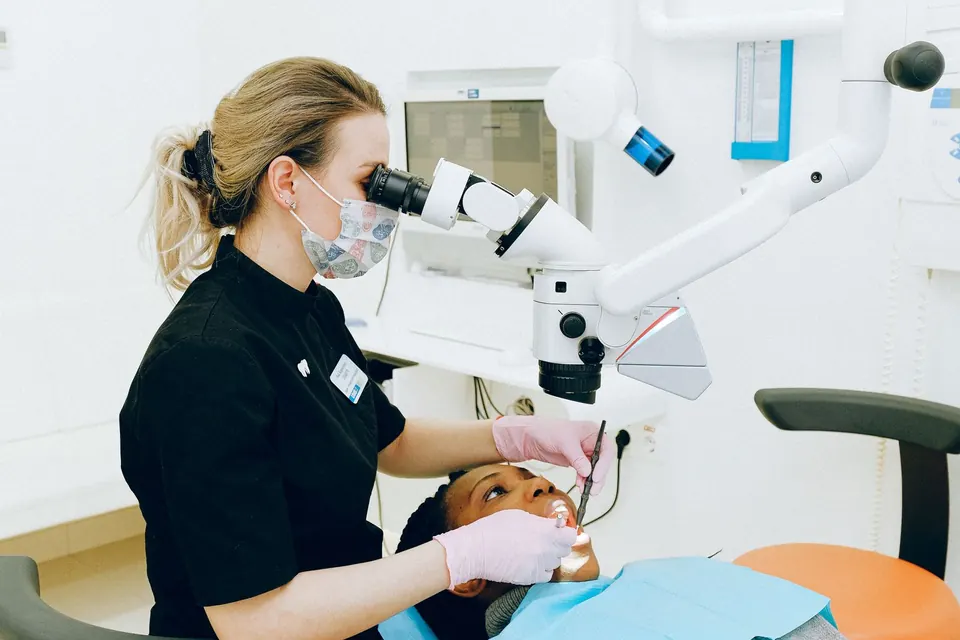 Dentist using a dental microscope to examine a patient