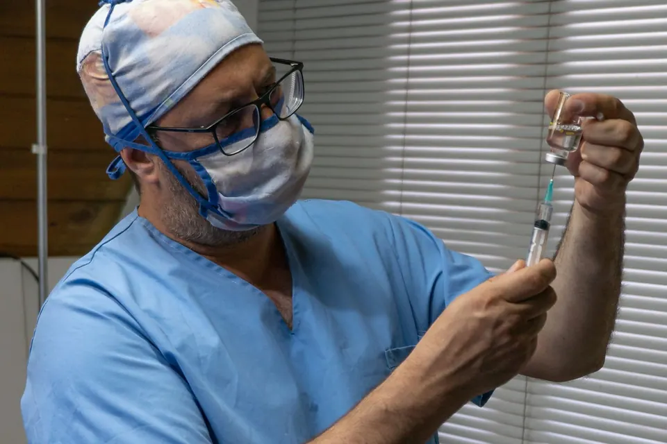 Surgeon in scrubs, cap and mask preparing for a procedure in a clinic