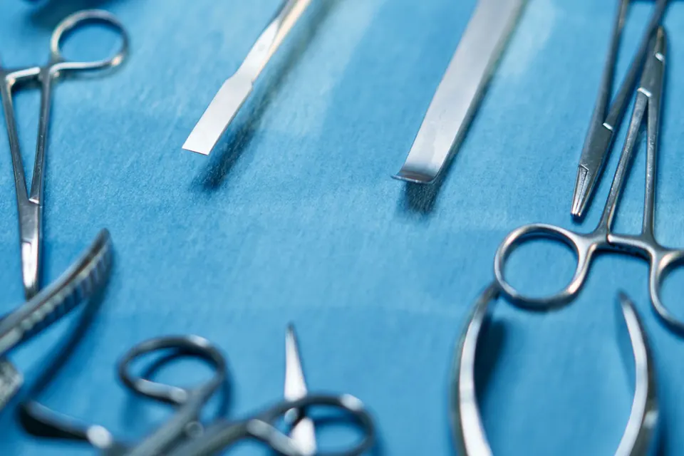 Sterile surgical instruments laid out on a blue surgical drape